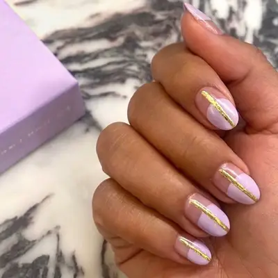 Pastel lilac nails with gold stripe down the center