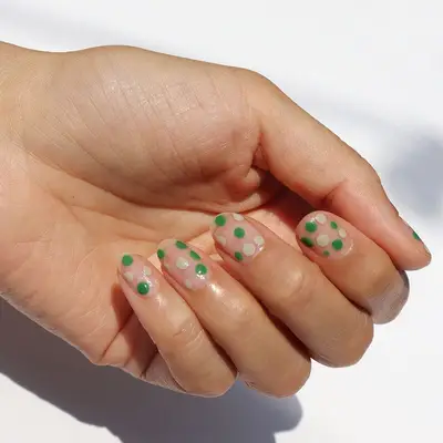 Green and white dots on nude nails