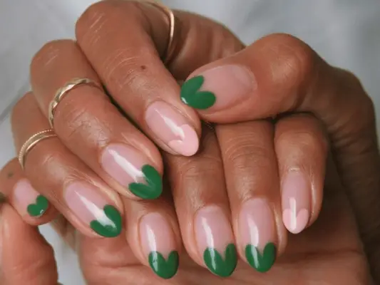 Hands with neutral nails and pink and green heart tips