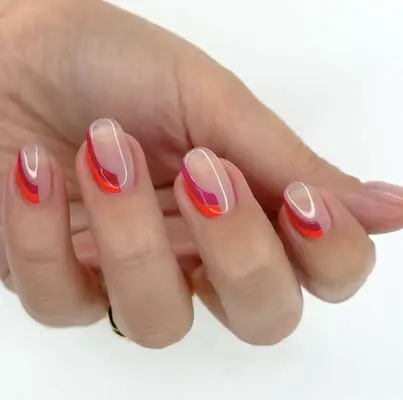 A hand with a manicure featuring red and pink gradient lines on clear nails, held in view by fingertips