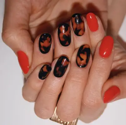 Person displaying hands with polished nails in two artistic designs