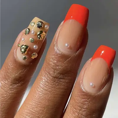 Manicure featuring decorative seashell-themed nail art on polished nails