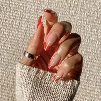 Hand with manicured nails featuring a red outline design