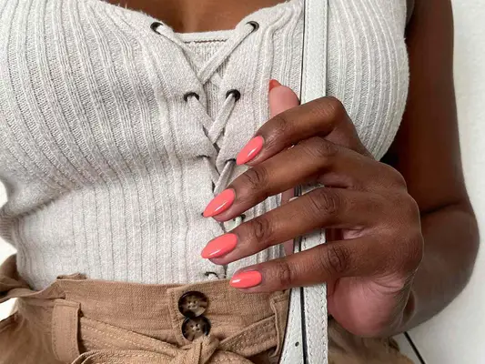 woman with coral manicure