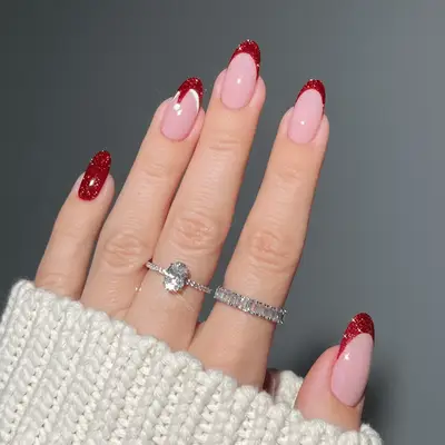 close up of hand with fresh manicure, sparkly apple red nails
