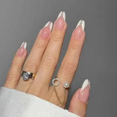 Manicure with negative space white split tip design and pearl accents