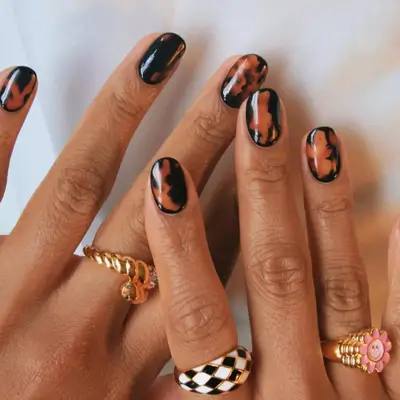 close up of tortoiseshell manicure on white sheet background