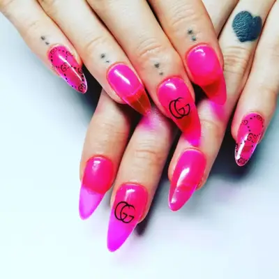 Pink jelly nails with the Gucci logo on the middle finger.