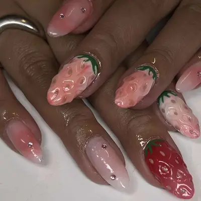 Close-up of hands with 3D strawberry-themed nail art designs