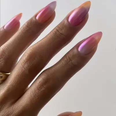 Hand with fingernails styled with a glossy, gradient finish