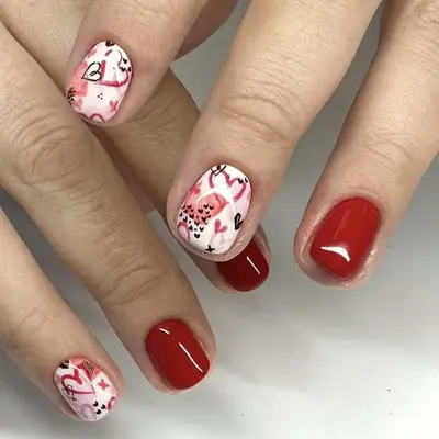 red manicure with heart accent nails