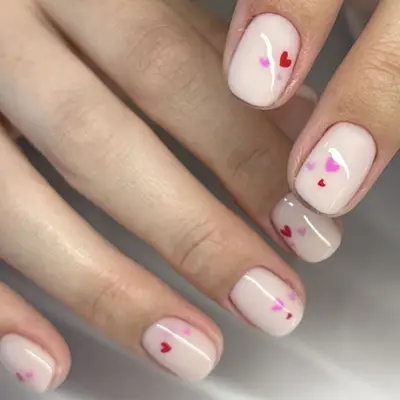 white nails with pink and red heart designs