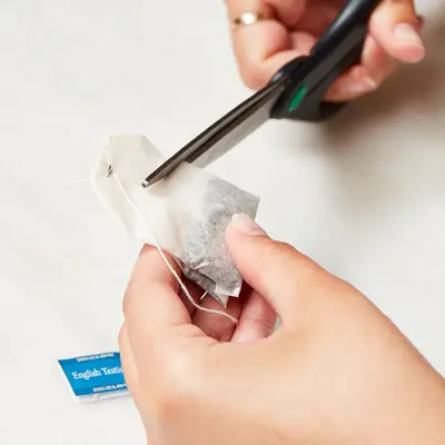 Woman cuts a tea bag