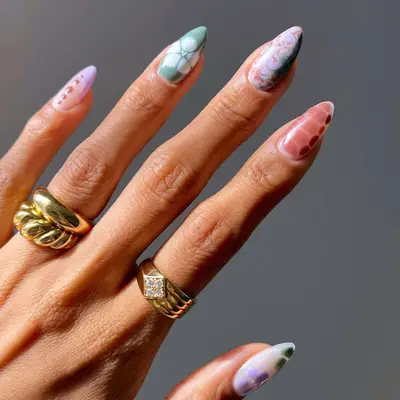 pastel green, purple, and red nails with abstract designs
