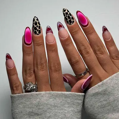 model with nails with animal print, pink aura, and heart decal designs