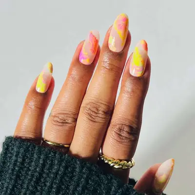 neutral nails with yellow, orange, and pink abstract shapes