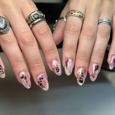 neutral pink nails with dark brown and camel spots