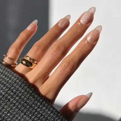 Nude manicure with a subtle milky silver sparkle on top.