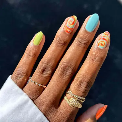 close up of orange, blue, and green tie dye nail art