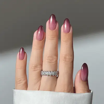 Close up of a chrome ombre manicure featuring mauve, berry, and burgundy shades.