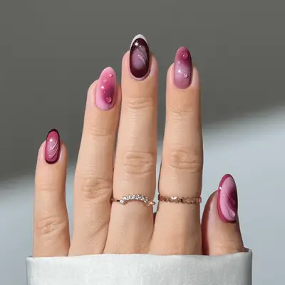 Close up of modern berry and mauve nails with airbrush an 3D droplet details.