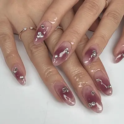Nude nails with a smoked mauve polish on top, accented with silver crystal gems.