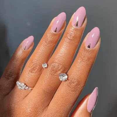 Mauve nails with triangular gold foil detail at the cuticle.