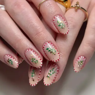 close up of hand showing off fresh manicure, one nail with red and white candy stripes, three nails plain red, one nail with red french tip