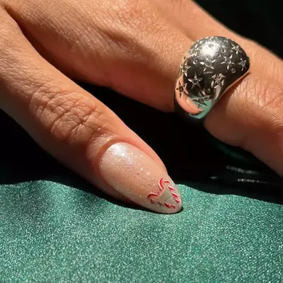 pink glitter nails with snowflake and peppermint accent designs