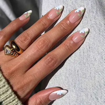 Close-up of manicure with delicate blue floral design and white French tips