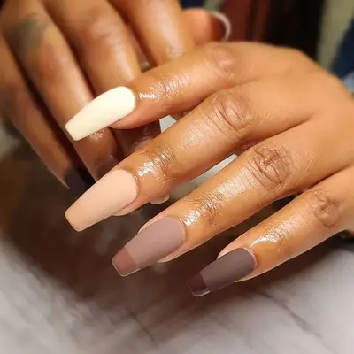 Close-up of hands with long, stylized nails showcasing different shades