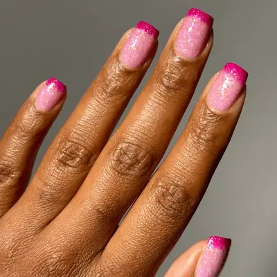 model with bright yellow and orange French tips with flower design on middle finger