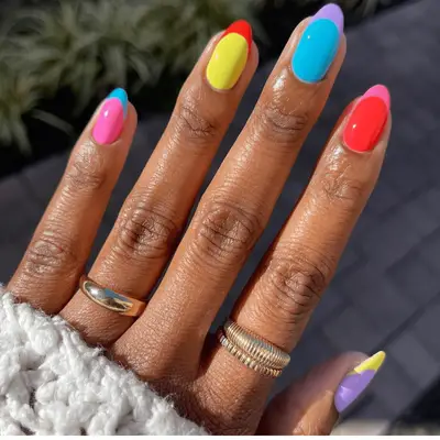 Two hands with manicured French nails, rings, and a watch