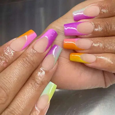 two hands with rainbow sunset french manicure tips