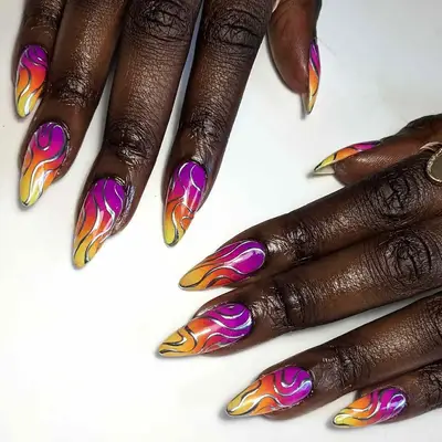 two hands with a purple, orange, and yellow with silver swirls manicure
