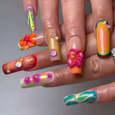 two hands with a multicolored sunset-inspired 3d manicure