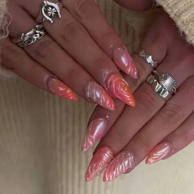 two hands with pink and orange sunset 3d manicure