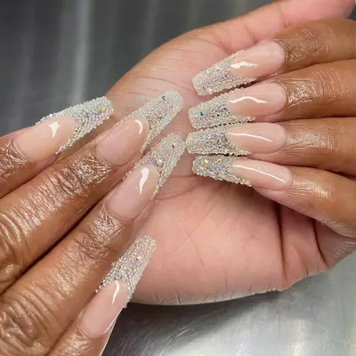 Close-up of hands displaying long manicured nails with intricate embellishments