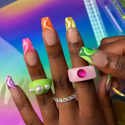 Hands with colorful nail art and decorative rings