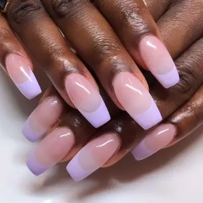 Close-up of hands showing manicured fingernails with light polish design