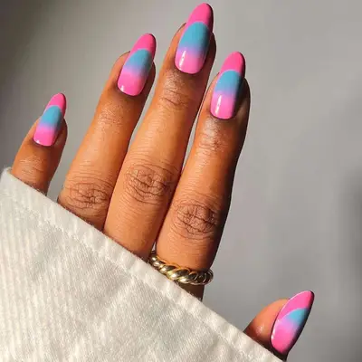 Hand with colorful manicured nails, each nail featuring a dual-tone design