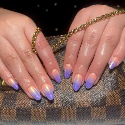 A lavender-peach ombré nail design topped with chrome