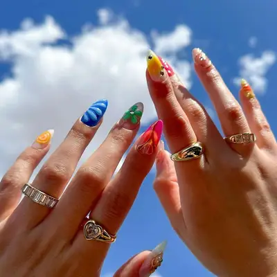 A mismatched manicure with multiple colors and 3D accents