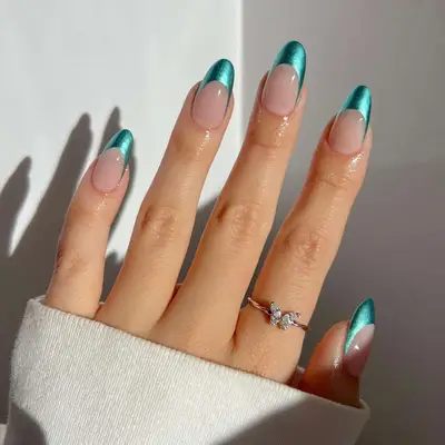 A French manicure with teal chrome tips