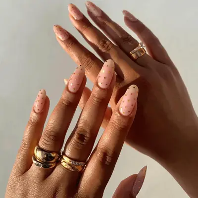 Nude nails with gold polka dots