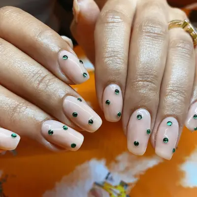 Nude square nails with green gemstones