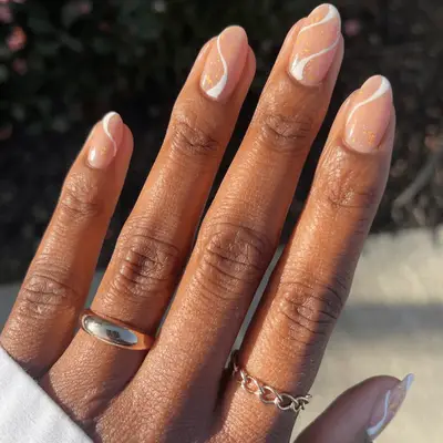 Gold, nude, and white swirl nails