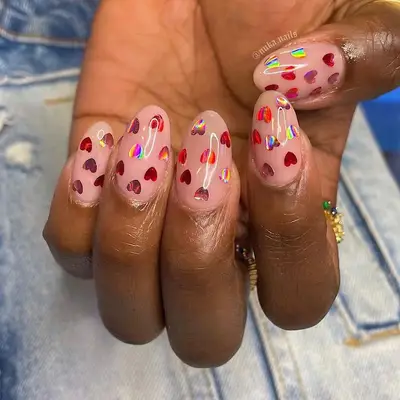 Peachy neutral manicure with holographic red heart decals