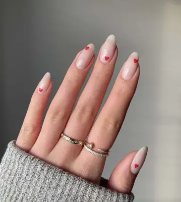 Nude nails with tiny red hearts dotting each one