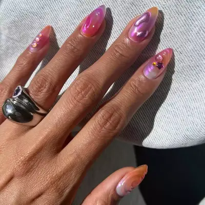 A hand with chrome polished nails wearing an engagement ring